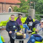 Uczniowie siedzą na dachu w kawiarni Cafe Borówka, piją kawę i gorącą czekoladę.